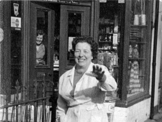 Mrs Moulsher outside her store Moulsher's village store on Market St, Bottesford. Mrs Moulsher is in the foreground, and rearing through the window of the store is Mrs Jean Dunsmore. | Contributed by Mrs Anne Moulsher