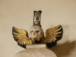 The memento mori on top of the tomb of the 5th Earl of Rutland in the chancel of St Mary's, Bottesford: a skull with gilded wings, an hour glass on the crown of the skull | Neil Fortey, 10/11/2013