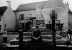 Cyclist resting on steps of Bottesford market cross