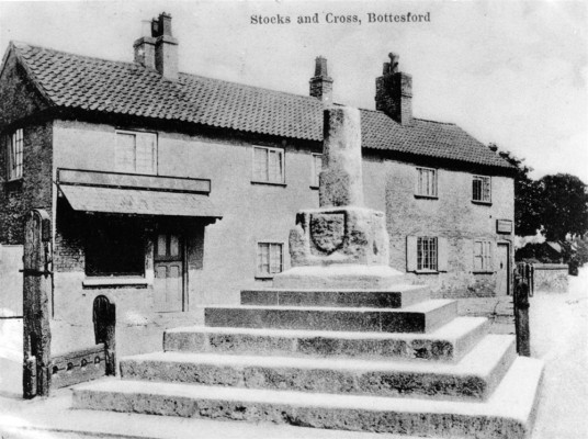 Postcard of Stock and Cross, shops behind Postcard of Stock and Cross, shops behind