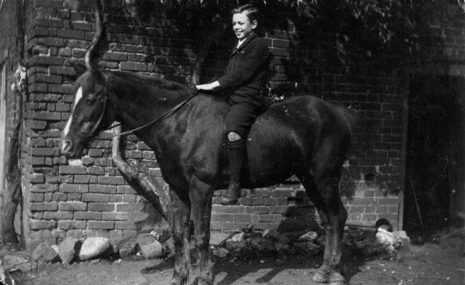 Tom Samuel seated on pony in yard