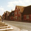Colour postcard of Market Cross and village school