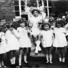 infant girls with May Queen in school yard