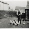 Reg Barke with chickens in yard at Bottesford Coffee House, during WW2