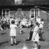 May Day children's maypole dance in village school yard