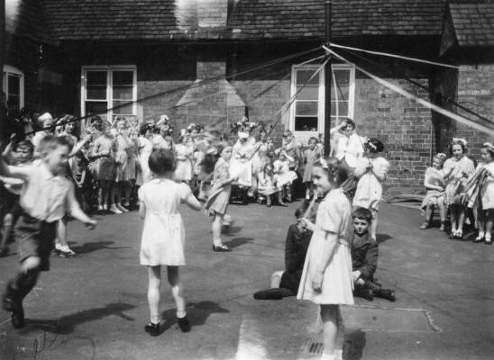 May Day children's maypole dance in village school yard