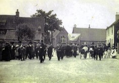 Village band marching in Church Street, inauguration of Edward Prince of Wales
