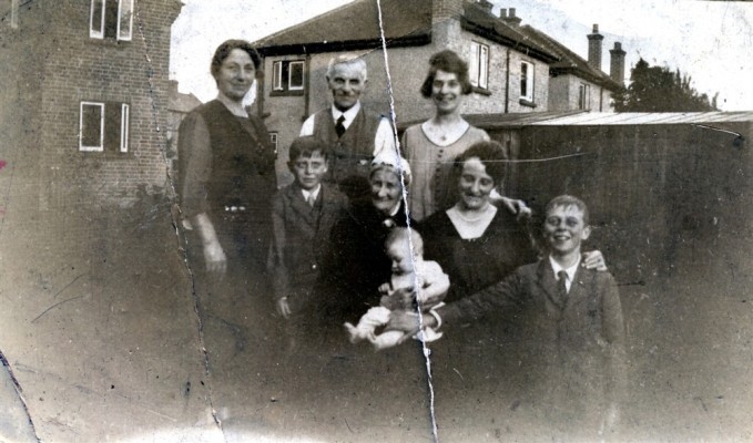Family group to rear of house, probably in Bottesford