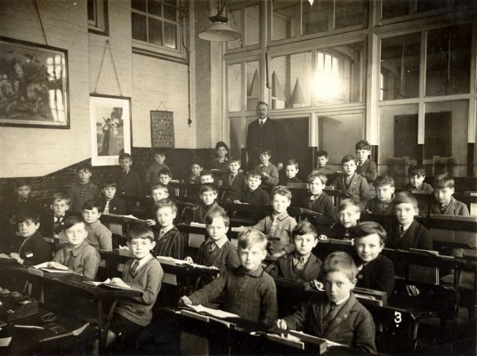School picture: boys in classroom with teacher, possibly a village school though the exact location is uncertain.