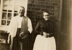 Elderly couple at cottage door, possibly parents of one of couple in BOT032_035