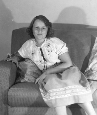 Helen Webb, sitting on a settee