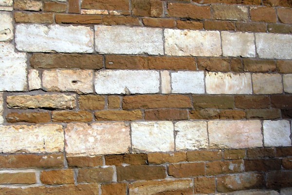 The wall of the Rutland Hospital, alternating courses of brown Marlstone Rock and pale Lincolnshire Limestone.