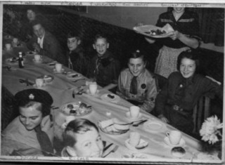 1st birthday party in 1956 after Jay Howitt became Scoutmaster. Back of table: Yolande Norris, Mrs Howitt, Neil Tinkler, John Wilkinson, Jill Howitt, Gillan Newton. Front of table: M. Ducker, Richard Cole