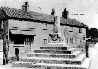 The Cross with the butcher's and right  John Sutton's shop