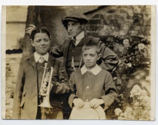 BOT132_004_MaryKaye_Sutton_02_1LR Bob Sutton (left) holding a cornet; Philip Sutton, his cousin, wearing a hat. Frank Sutton his younger brother, holding a straw hat. Frank died in 1919 a casualty of the Spanish Flu epidemic. Philip served in the Durham Light Infantry. He survived injury at the Somme in September 1916. He was killed in the March 1918 German Offensive.