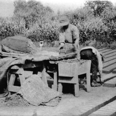 Picture 9. The wet, moulded brick is tipped from the mould and laid on the 'flat' to dry for a day. Later it will be set on the 'hack', a slightly raised wooden platform until it is dry enough for firing.