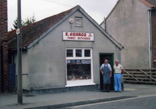 Eric George with Ian Norris in the early 1990s. Modern hygiene regulations required the removal of the original stable door, renovation of the windows and installation of refrigeration and ventilation. The hipped  roof shown in the early photograph has been replaced with a louvered vent