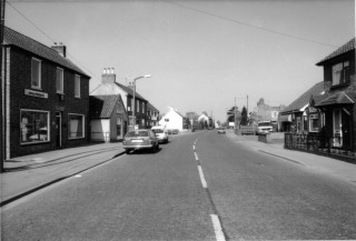 High_St__MH1 High Street towards Barkestone Lane - left hand side: Andrew's-Weatherfoil; Eric George - Butcher; Old Post Office; Bullock and Driffill. Right hand side: Norris Funeral Directors Chapel of Rest; VG shop