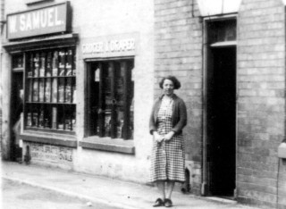 Mrs_Samuel_,_1st_wifw_of_Tom_samuel_c._1935,_close_crop1 W. Samuel's shop c 1935