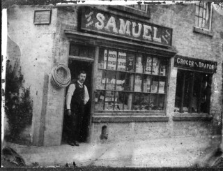 William_Samuel_Church_st051 William Samuel standing in the shop entrance on Market Street in the early 1900s from a glass photographic plate, measuring 3.25 x 4.25 inches. The signs on the end wall indicate that the premises were licensed to sell cigarettes and tobacco. The sign over the shop also advertises 'boots and shoes' and 'suits to measure'