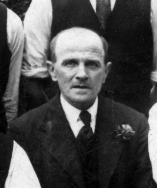 AHE0008_JackAsher A photograph of Jack Asher, c.1930 or later, as one of the Bottesford Ex-servicemen's Club skittles team, outside the club hut on Albert Street (now the Scout Hut). | From the private collection of Mrs Anne Hewitt