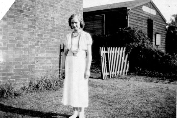 BOT119_003 AHE0003 Woman standing by farm buildings