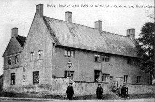 Bedesmen, dressed for church, in front of the Earl of Rutland’s Hospital, an almshouse established in the late 16th Century to house single retired men from the village.