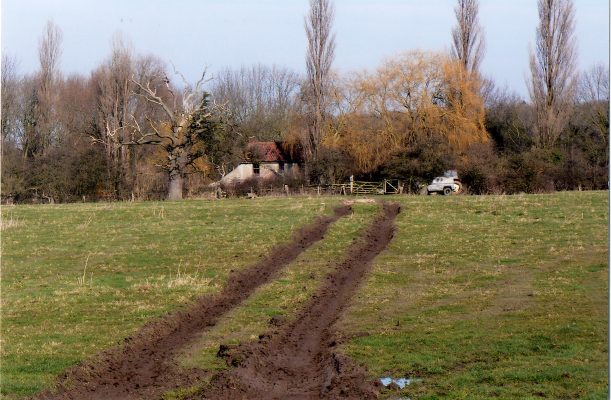 The Lock House glimpsed across the field gate by the lane by Stenwith Mill farm. | Margaret Langton