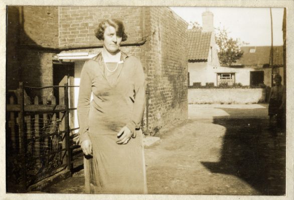 Evelyn Marston in the alleyway between her home on the right and the end of Queen St Mill on the left. In the background is Queen Street and on the far side part of Tappins cottage, where the lean-to was used as a fish and chip shop at one time. None of these building are still standing.