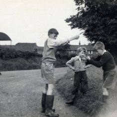 BOT177_069 Marston album3 08 'Geoffrey playing conkers with Tony and Angela Marsh on the corner of Station Road and Rectory Lane, Bottesford, September 1960.' | Janet Dammes