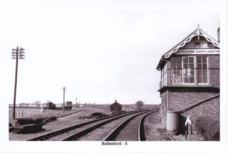 Bottesford for Belvoir - slide 31 Bottesford South signal box c.1960, around the time of the 'Beeching cutbacks'. The track of the Newark line has been removed but the bridge where it passed beneath the Nottingham-Grantham line is clearly seen. Lines of trucks stand on the former SW spur, now used as sidings after the spur was disconnected from the remaining Joint line which still runs along the old SE spur to connect with Bottesford and Grantham. | Postcard, photographer uncertain.