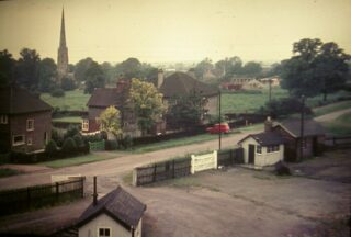 Bottesford for Belvoir - slide 43a A view, probably taken from one of the upper windows of the station wharehouse in the 1950s, of the station goods yard fenced off from Station Road. Three 1950s houses are on the opposite side of the street backing on to Beckingthorpe fields now the site of the Beckingthorpe Road estate. | From the collection of Mrs Beryl Smith
