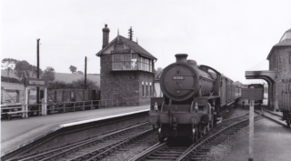 Bottesford for Belvoir - slide 41 A passenger train entering Bottesford station on the down line, passing between the grain wharehouse and the tation signal box. | From an old postcard