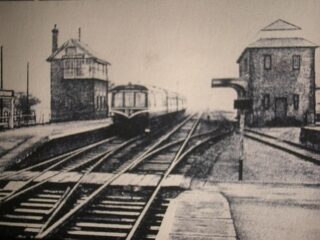 Bottesford for Belvoir - slide 41a A very grainy picture of a west bound diesel train stopping at Bottesford. The track-level pedestrian crossing is in the foreground. | Bottesford Local History Archive