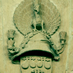 P1050394_07 Mounted above the first pillar of the north nave arcade, a shield bearing the de Roos arms, surmounted by a helmet (or a Cap of Maintenance) and the Peacock resplendent, the emblem of both the de Roos and Manners families. | Neil Fortey