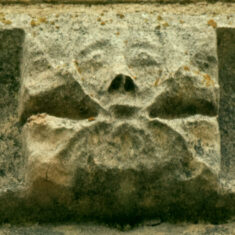 P1050513_06 One of the carvings of flowers (fleurons) seen on the frieze, which is this example encloses a human face in the form of a green man.