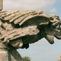 A figure with dragon’s wings, folded human-like legs and a dog-like face, this is the lower carving on the eastern end of the northern side of the clerestory. | Neil Fortey