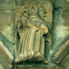 The roof of the nave is supported by stone corbels carved as angels, some holding scrolls, others holding shields. As with many of the other carvings mounted close beneath the roof, these have their eyes picked out in black paint, in these cases applied to the pupils rather than the whole eyes as in the case of the demonic carvings. | Neil Fortey