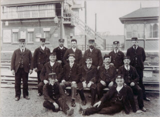 Picture 7 - Station staff Bottesford c.1911, Stationmaster Richard Gaylard surrounded by his staff. Note the signal box and waiting room on the opposite east-bound platform—not there now! | From the personal collection of Christopher Harris, Bottesford Local History Archive